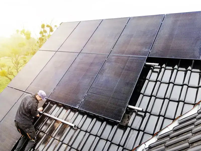 Zonnepanelen op een pannendak, gezien vanaf de dakrand