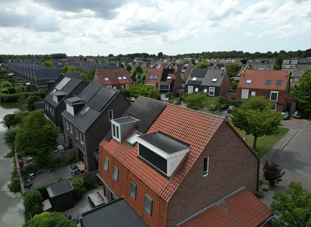 Dronefoto van een woonwijk waar meerdere daken zonnepanelen van Solar Green hebben