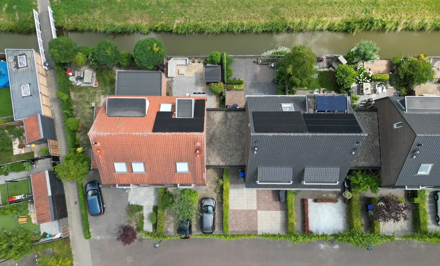 Dronefoto recht van boven: woning met een dak vol zwarte zonnepanelen